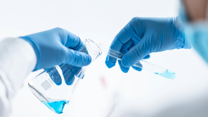 Blauwe laboratoriumhandschoenen met glaswerk